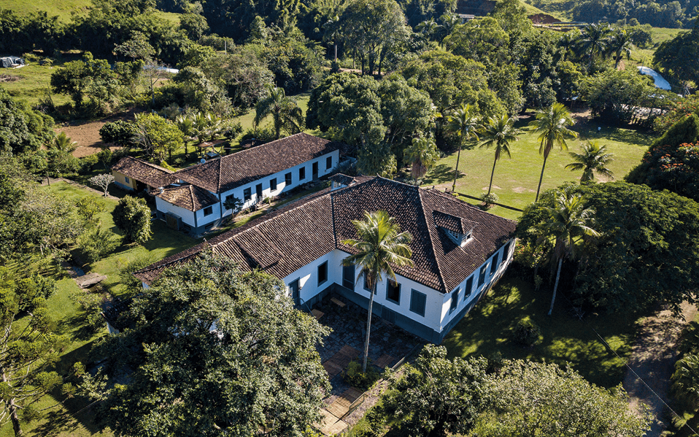 A casa maior, abaixo, est a casa grande. Acima, a casa onde caf  colhido era espalhado e trabalhado.